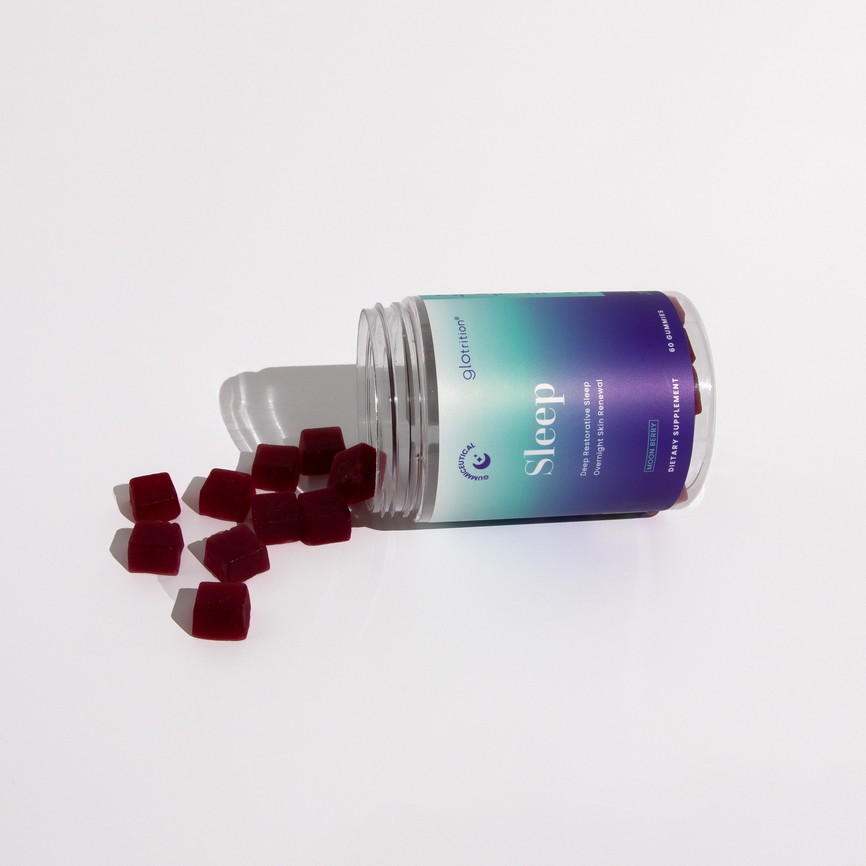 Glotrition Sleep gummies spilling from an open jar on a white background—moon berry gummiceutical for deep restorative sleep.